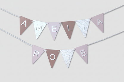 Personalized name banner with 'AMELIA ROSE' on pastel-colored fabric flags.